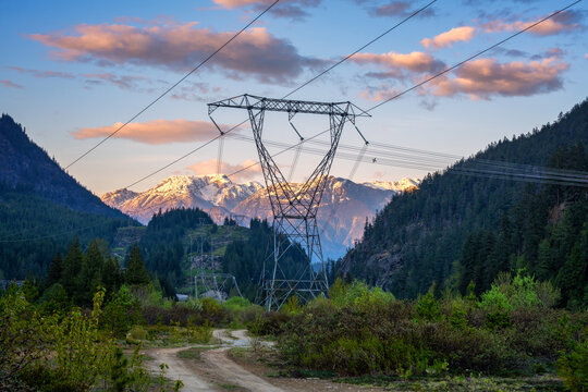Power lines and transmission towers spanning a valley with snow