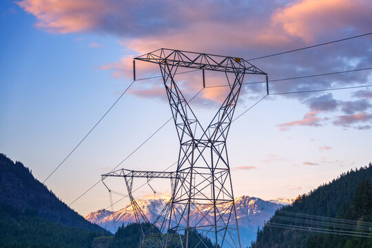Power lines and transmission towers spanning a valley with snow