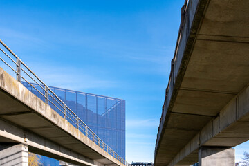 A striking view of modern infrastructure featuring intersecting concrete structures against a bright blue sky, symbolizing progress and the interconnected world of architecture and transport.