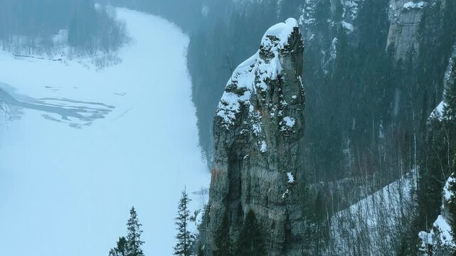 The icy river Usva in winter, flowing through a rocky area in the Perm region, stone pillars. Winter on the banks of the Usva mountain river.Russia, Ural Mountains. Frozen river covered with snow.4K