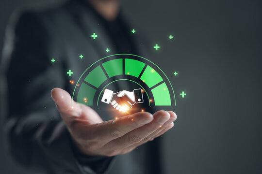 Businessman holding a digital partnership trust level meter with handshake icon. Concept of business collaboration, successful partnership, corporate trust, joint ventures, and mergers.