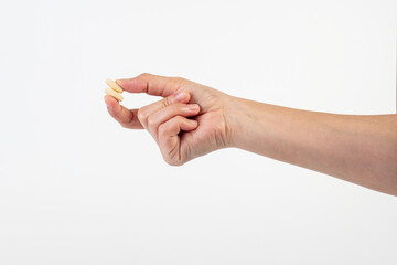 Medicine or vitamins in hand on white background