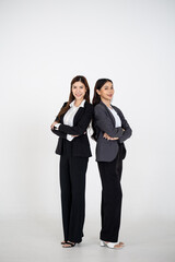 Two Asian women dressed in business attire posing on a clean white background, representing modern corporate roles, confident teamwork, and professional collaboration for office and company branding v