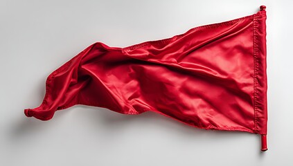 A vibrant red flag waves against a plain neutral background