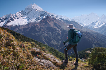 Young female backpacker admiring Ama Dablam peak on Everest Base Camp trek in Nepal