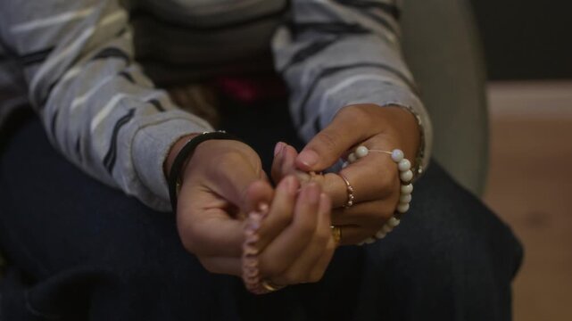 Cropped shot of hands of anonymous teenager fidgeting with bracelets feeling stressed on counseling session