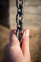 Main gauche tirant sur une  grosse chaîne