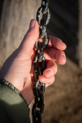 Main gauche tenant une chaîne