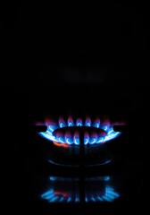 Vibrant blue and orange gas flame igniting from a kitchen burner, providing essential heat for cooking and various domestic tasks ,heating element ,blue flame ,heat source