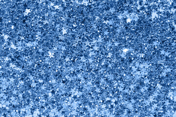 Sparkling blue star confetti background with shining metallic glitter texture.