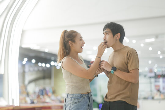 Couple Using a Mobile Phone Together in a Shopping Center