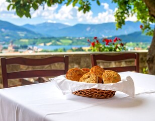 A basket of bread rolls sits on a table with a stunning mountain backdrop