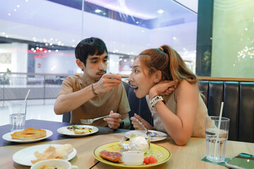 Asian couple happily enjoying a meal together at restaurant,