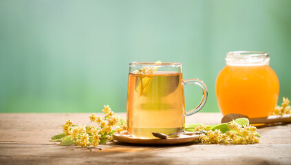 A glass of linden tea. Linden flowers and honey in the background