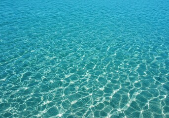 Vibrant blue ocean water gently laps against the shore, reflecting the natural light. Crystal clear liquid texture. Serene marine environment ,horizon ,vast ,marine