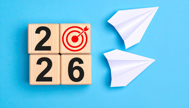 2026 calendar wooden block new year planning organization schedule timeline sustainable natural simplicity arrival agenda tactile target paper airplane blue background - Powered by Adobe