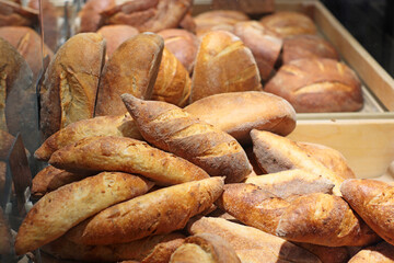 A tempting selection of fresh bread loaves with a crisp golden crust displayed in a bakery. The assortment showcases traditional, artisanal baking at its best.