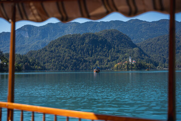 Fototapeta premium Pilgrimage Church of the Assumption of Mary (Bled Island Church). Bled Island. Stunning Panoramic View of Lake Bled with Iconic Island and Castle, Slovenia. Romantic spot. Typical Bled boat (Pletna).