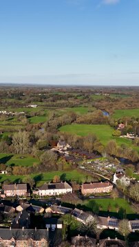 Portrait aerial drone footage of the town of Ripon in North Yorkshire in the UK showing typical British housing estates and streets along side the Yorkshire country side in the autumn time.