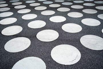 This image showcases large circular patterns on a dark pavement, creating an intriguing visual contrast that catches the eye and enhances outdoor aesthetics.