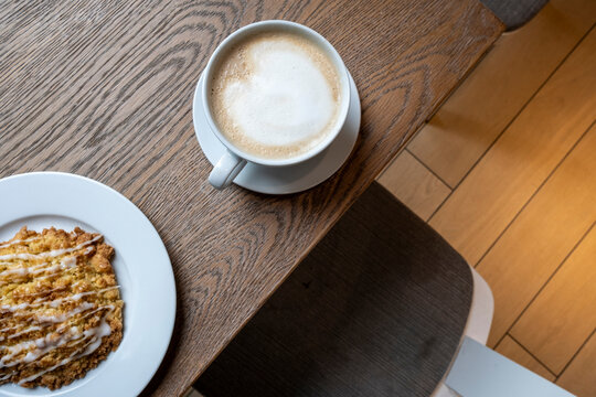 A beautifully arranged coffee and pastry set on a wooden table creates a warm inviting atmosphere, perfect for enjoying a cozy moment or social gathering.