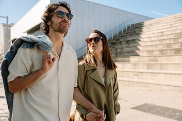 A man and a woman are talking and holding hands while she looks at him