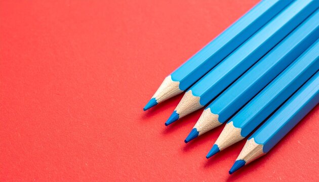 &ldquo;Two blue pencils on vivid red surface, symbolizing contrast, creativity, and expression.&rdquo;