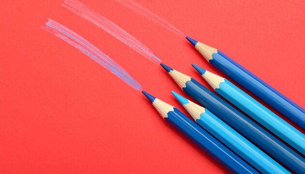 &ldquo;Two blue pencils on vivid red surface, symbolizing contrast, creativity, and expression.&rdquo;