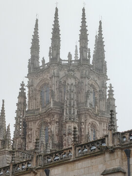 Pin&aacute;culos g&oacute;ticos entre niebla con detalles ornamentales en piedra del cimborrio de la Catedral de Burgos, Espa&ntilde;a