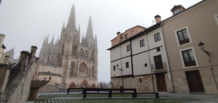 Catedral de Burgos entre niebla con plaza y edificios hist&oacute;ricos