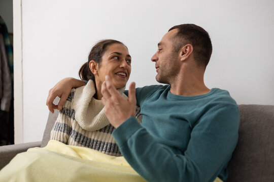 Couple relaxing on couch having intimate conversation