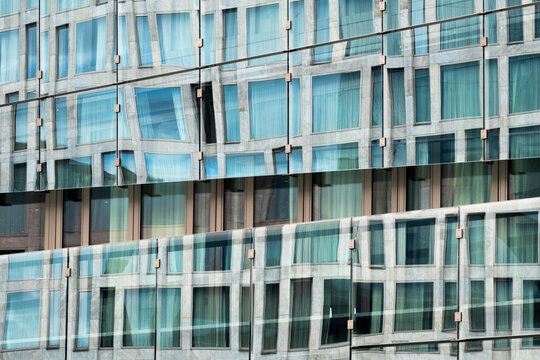 This image shows a dynamic glass facade with varied angles, showcasing architectural creativity that elicits feelings of modernity and sophistication.