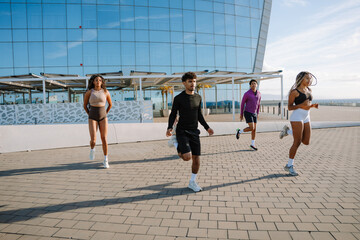A group of four athletes running in place with their legs thrown back