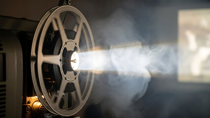 Obraz premium Film Projector Reel Spinning Beam Of Light Through Smoke 97591159 1