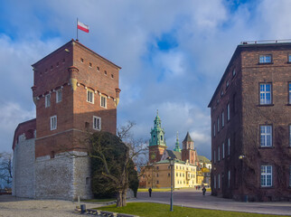 Obraz premium Entrance to Wawel castle in Krakow, Poland. Tower and wall of vintage fortress and Catholic temple. Picturesque blue sky with clouds