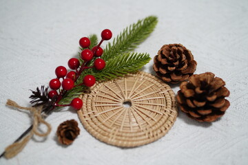 Natural Christmas Decoration with Pine Cones, Greenery, Red Berries, and Woven Mat for Festive Celebrations and Home Decor Inspiration