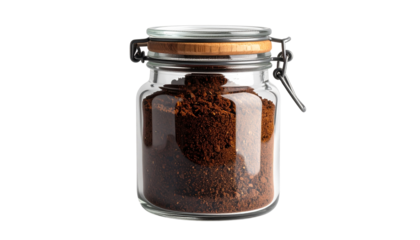 A glass jar of ground coffee stands isolated on solid white background