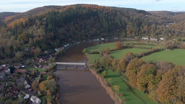Aerial drone view flying towards Tintern village and the River Wye in autumn