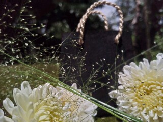 Black Shopping Bag with White Flowers on Moss Background &ndash; Natural Decorative Still Life