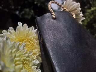 Black Shopping Bag with White Flowers on Moss Background &ndash; Natural Decorative Still Life