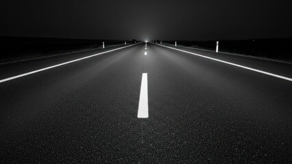 Dark asphalt road at night, white lines guide into the vanishing distance