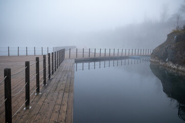 Obraz premium Foggy Lakeside Boardwalk Scene
