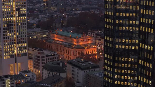 Aerial view of the Alte Oper concert hall in Frankfurt am Main, Germany. Nighttime cityscape with illuminated skyscrapers and streets