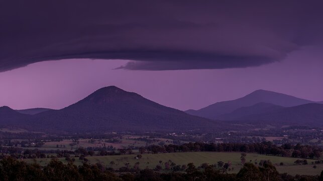 midgard. Dark purple storm clouds gathering before rainfall, dramatic sky formation, natural weather phenomenon. travel magazines, destination branding, designed for travel destination branding.