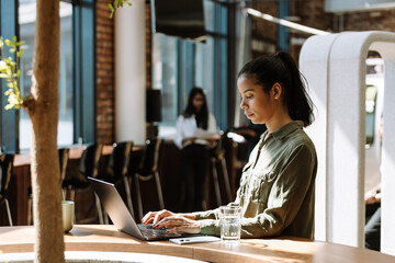 Female worker typing on laptop while sitting at desk