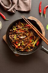Fried thinly sliced beef steak with peppers in cast iron skillet