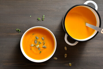 Creamy pumpkin soup garnished with seeds and thyme