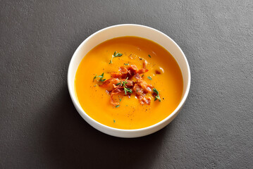Creamy pumpkin soup with roasted bacon and thyme