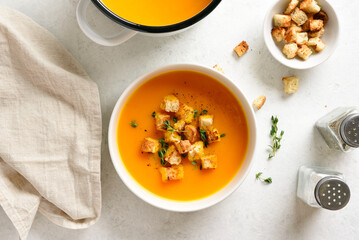 Delicious creamy pumpkin soup garnished with croutons and thyme