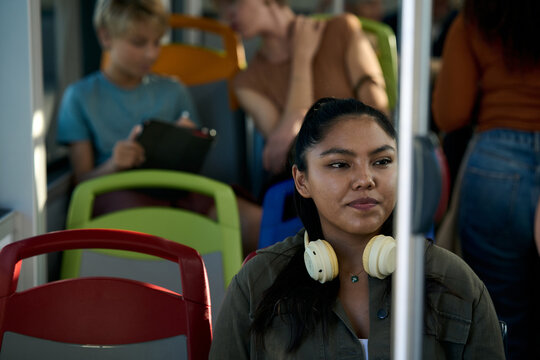 Young woman commuting on public transport with headphones - Powered by Adobe